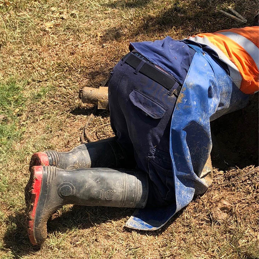 Tradies Gear no-buckle belt worn by worker kneeling in the dirt, showcasing flexibility and comfort in tough work conditions