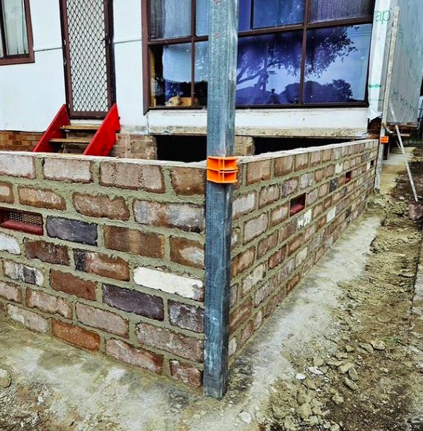 Brick wall under construction using Tradies Gear MAGSY magnetic corner blocks for precise string line setup in masonry work
